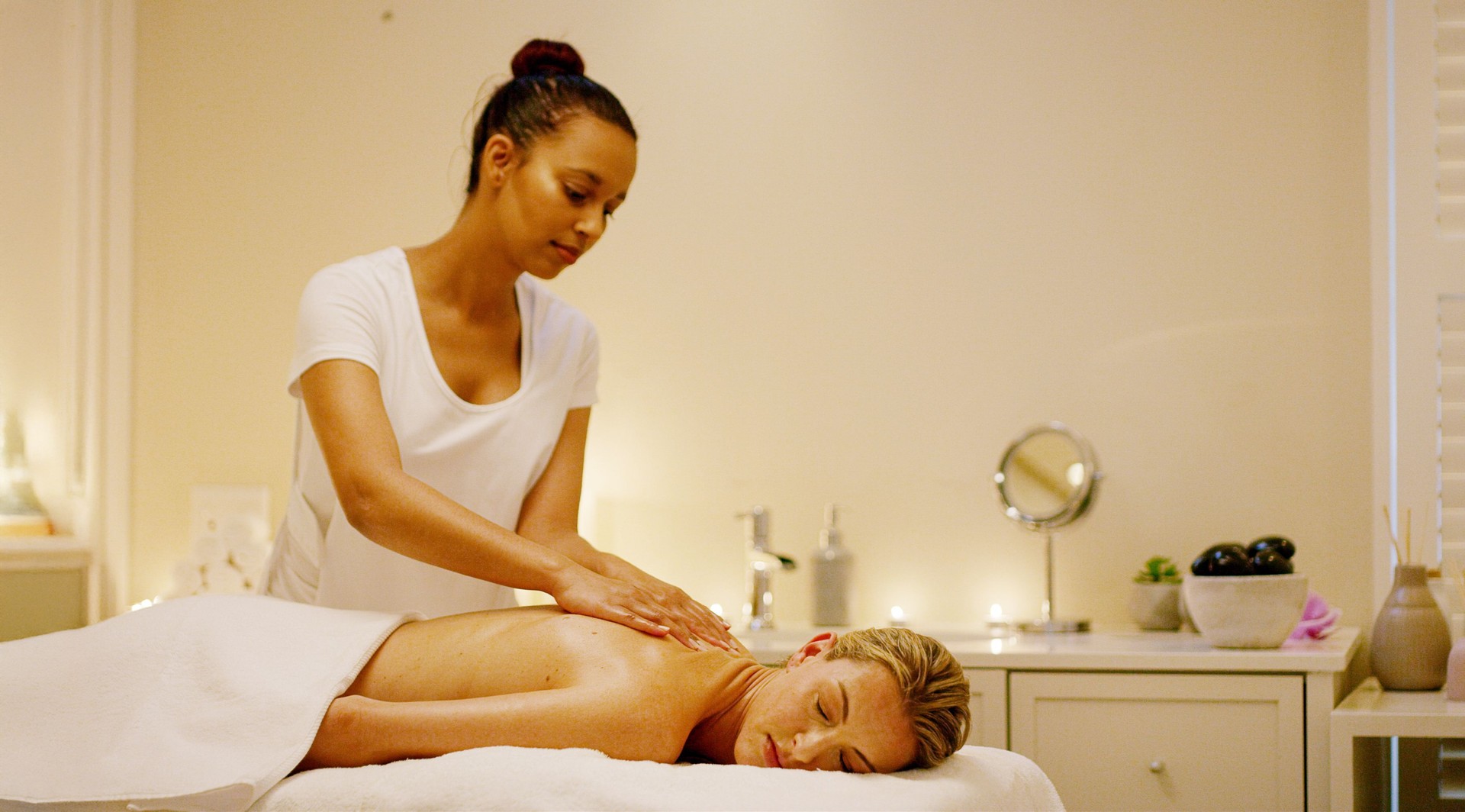 Woman, therapist and back massage in spa for relax, sleeping and deep tissue treatment at luxury hotel. Peace, client and masseuse in resort for tension relief, stress management and hospitality